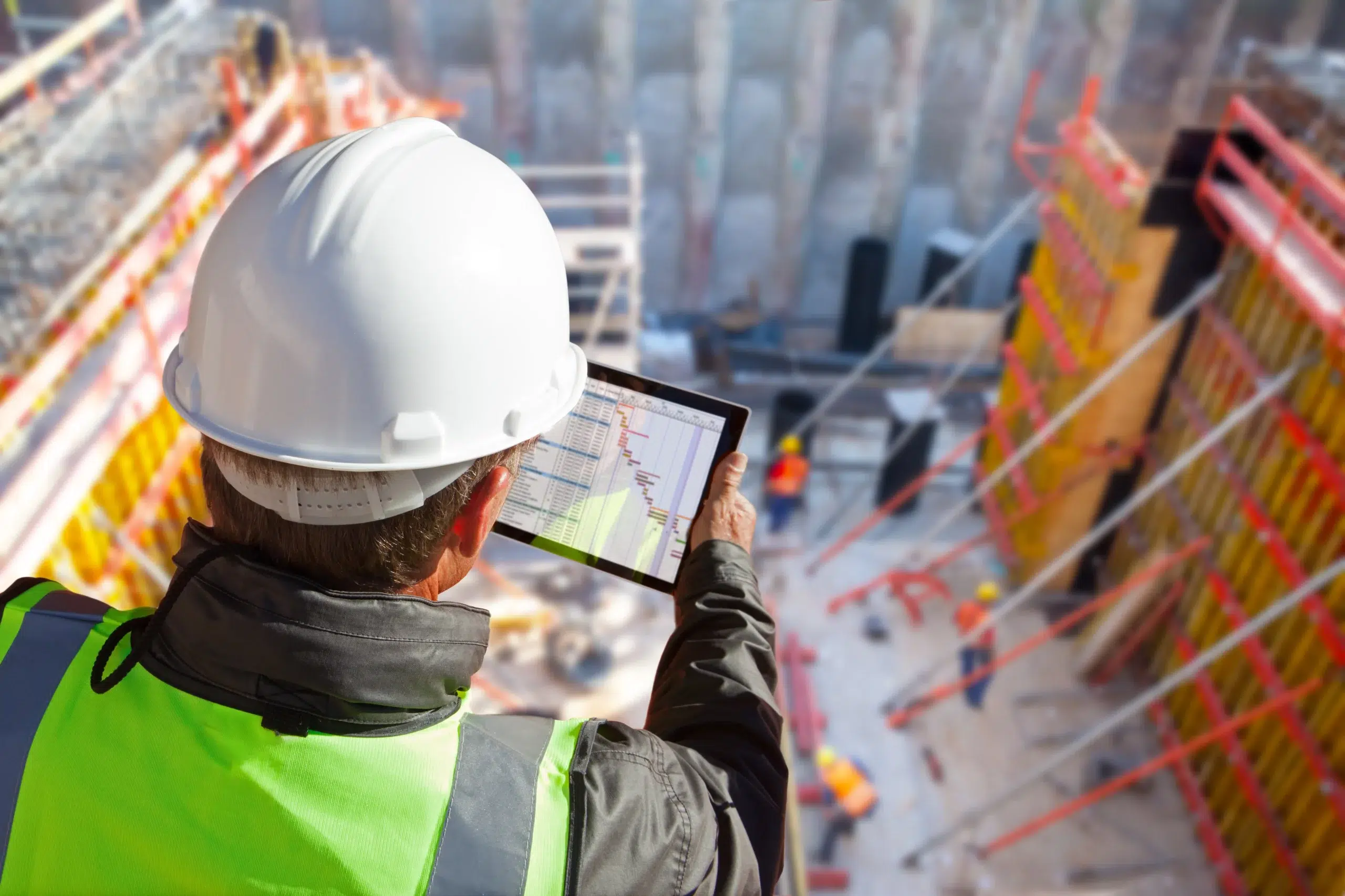 Overhead image of a construction crew with a worker consulting a profit graph.