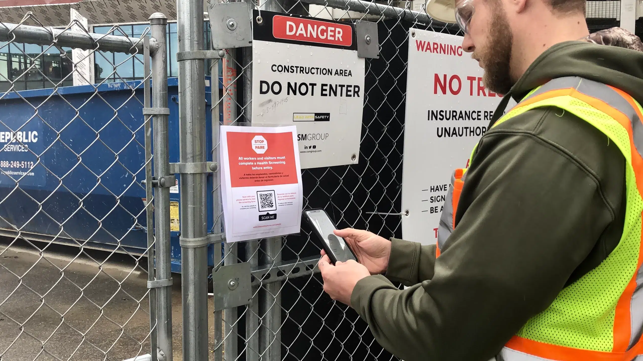 Construction worker enters a job site with a mobile health screening app built by SPARK.